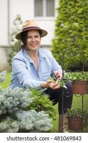 Mature Woman Gardening In Her Backyard