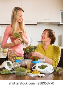 Mature Woman And Girl  With Medicinal Herbs Brewing Herbal Tea