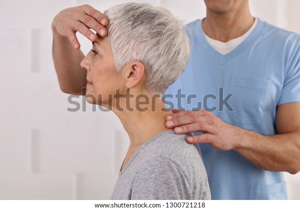 Mature\
Woman having chiropractic adjustment. Osteopathy, Physiotherapy,\
acupressure, holistic care. Craniosacral\
therapy