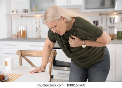 Mature Woman Having Heart Attack In Kitchen