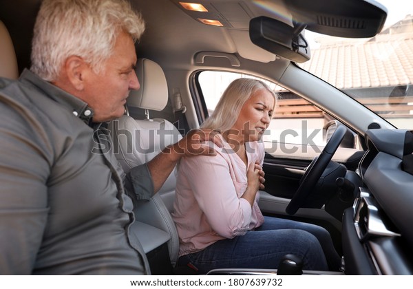 Mature\
woman having heart attack near her husband in car\
