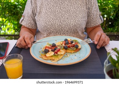 Mature Woman With Healthy Summer Breakfast, Classic American Pancakes With Banana, Kiwi, Fresh Berry And Honey