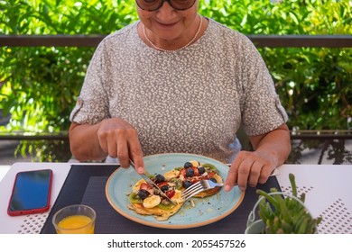 Mature Woman With Healthy Summer Breakfast, Classic American Pancakes With Banana, Kiwi, Fresh Berry And Honey