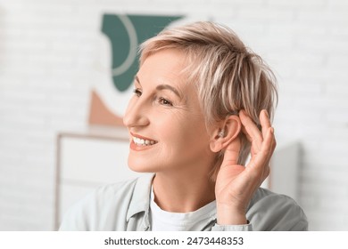 Mature woman with hearing aid in room - Powered by Shutterstock