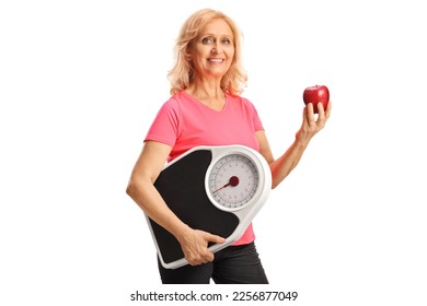 Mature woman holding a measuring scale and a red apple isolated on white background - Shutterstock ID 2256877049