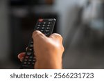 Mature woman holding the TV remote while watching television at home