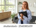 Mature woman with Holy Bible and prayer beads at home