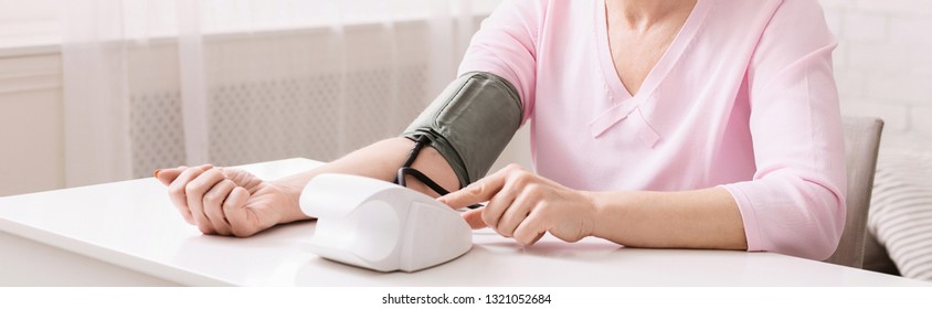 Mature Woman With Hypertension Measuring Blood Pressure Herself, Panorama With Empty Space