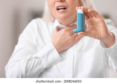 Mature Woman With Inhaler Having Asthma Attack In Office