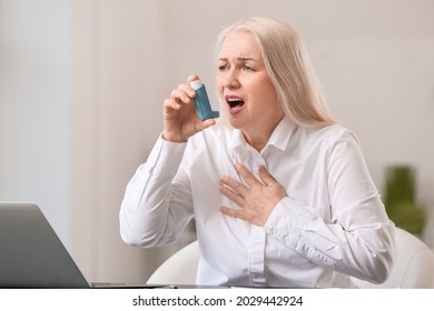 Mature Woman With Inhaler Having Asthma Attack In Office