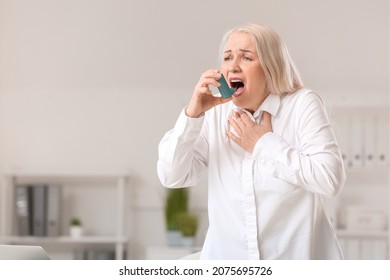 Mature Woman With Inhaler Having Asthma Attack In Office