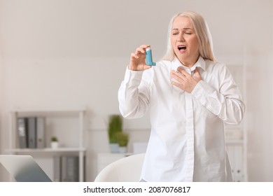 Mature Woman With Inhaler Having Asthma Attack In Office