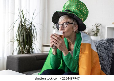 Mature Woman With Irish Flag On Shoulders Holding Glass Of Beer And Celebrate Saint Patrick Day