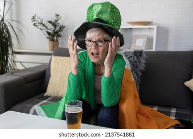 Mature Woman With Irish Flag On Shoulders Holding Glass Of Beer And Celebrate Saint Patrick Day