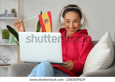 Mature woman with laptop studying Spanish online at home