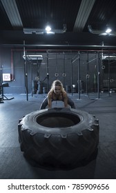 Mature Woman Lifting Tire Wheel In Crossfit Room