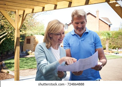 Mature Woman Looking At Design Plan With Landscape Gardener