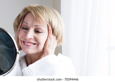 Mature Woman Looking At Herself In The Mirror