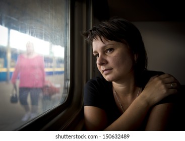 Mature Woman Looking Into Window Of Train. Real People Series.