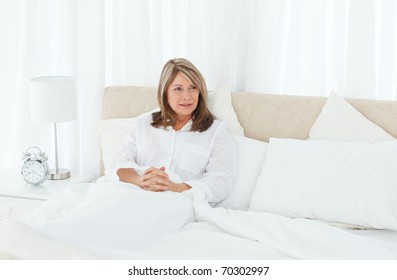 Mature Woman Lying Down In Her Bed At Home