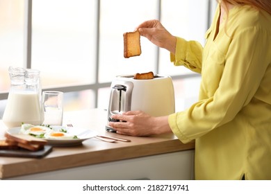 Mature Woman Making Tasty Toasts In Kitchen