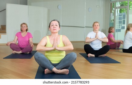 Mature Woman Making Yoga Meditation In Half King Of Fish Yoga Pose - Agni Stambhasana