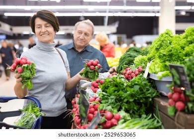 Mature woman and man selecting vegetables in - Powered by Shutterstock