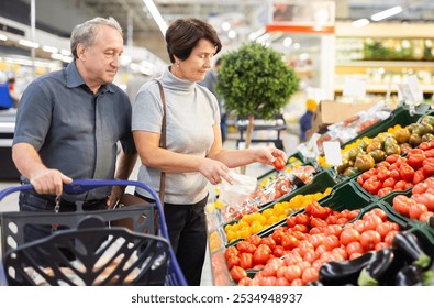 Mature woman and man selecting vegetables in - Powered by Shutterstock