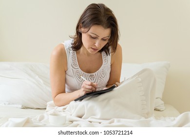 Mature Woman Morning Sitting In Bed Writing In Notebook