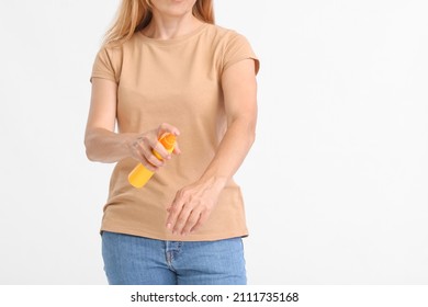 Mature Woman With Mosquito Repellent On Light Background