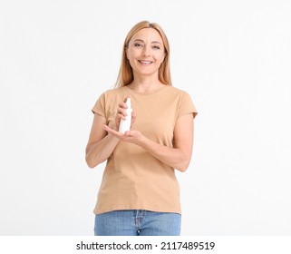 Mature Woman With Mosquito Repellent On Light Background