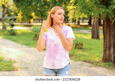 Mature Woman With Mosquito Repellent In Park