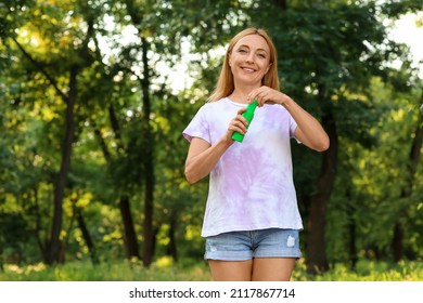 Mature Woman With Mosquito Repellent In Park