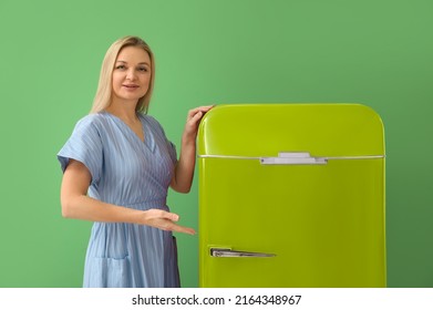 Mature Woman Near Stylish Vintage Fridge On Green Background