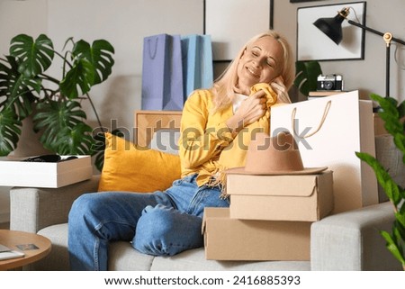 Mature woman with new purchases at home. Online shopping