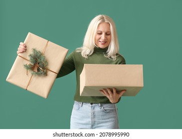 Mature Woman Opening Christmas Gift Box On Color Background