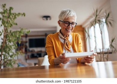 Mature Woman, Opening A Gift She Received From Her Coworkers.