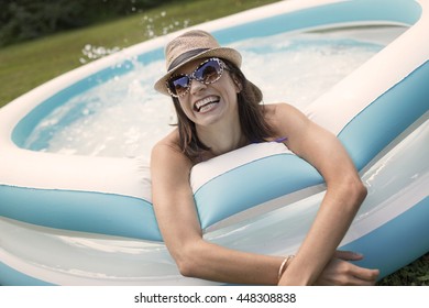 Mature Woman In Paddling Pool, Splashing Water