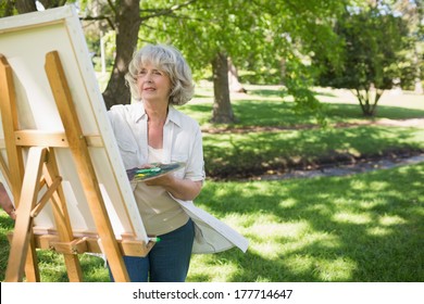 Mature woman painting on canvas in the park - Powered by Shutterstock