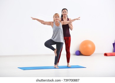 Mature Woman With Personal Yoga Instructor Indoors