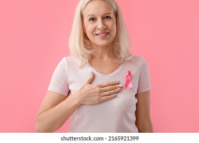 Mature woman with pink ribbon on color background. Breast cancer awareness concept - Powered by Shutterstock