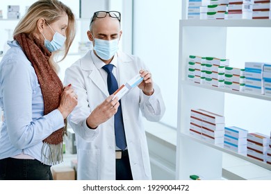 Mature Woman In A Protective Mask Asking Questions To A Pharmacist.