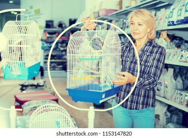 Mature Woman Purchasing Bird Cage In Petshop