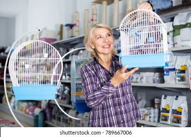 Mature Woman Purchasing Bird Cage In Petshop