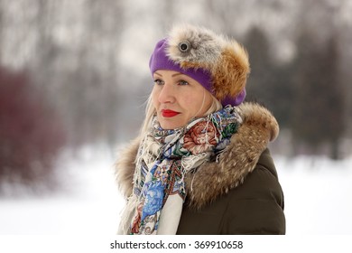 Mature Woman In Purple Beret And Winter Clothes On Blur Natural Snowy Background