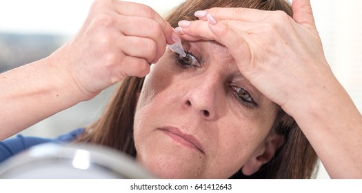 Mature Woman Putting Eye Drops In Her Eye