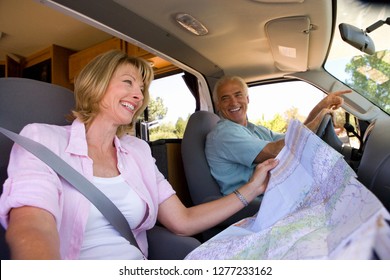 Mature woman reading map in motor home with husband driving