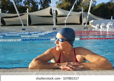 Mature Woman In Red Bathers Doing Swim Exercises, Keeping Healthy And Fit In Swimming Pool.