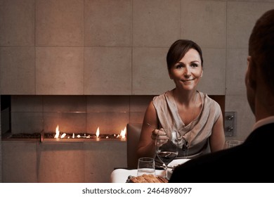 Mature, woman and relax on date at restaurant with food and wine on table at fine dining dinner, Person, smile and enjoy glass of luxury alcohol on holiday or listening to partner in conversation - Powered by Shutterstock