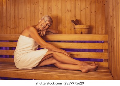 Mature woman is relaxing in sauna. Healthy lifestyle for elderly people. Spa concept.